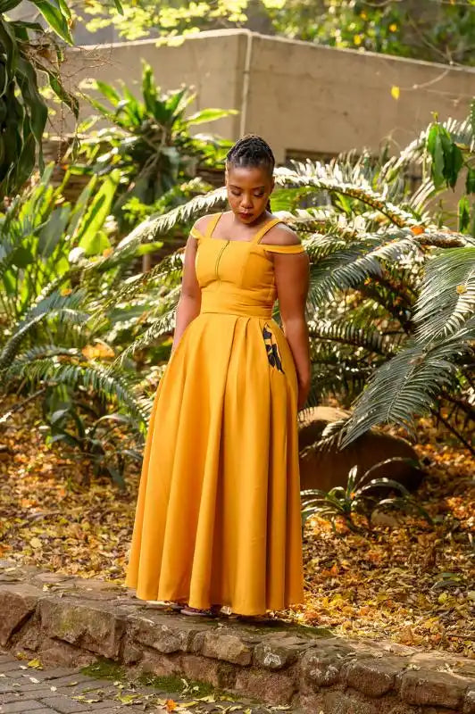 A flowing mustard yellow off-shoulder maxi dress.